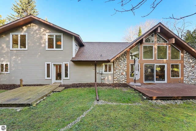 rear view of property featuring a wooden deck and a yard