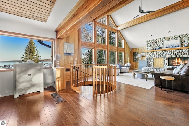 interior space with a fireplace, wood-type flooring, beamed ceiling, and a water view