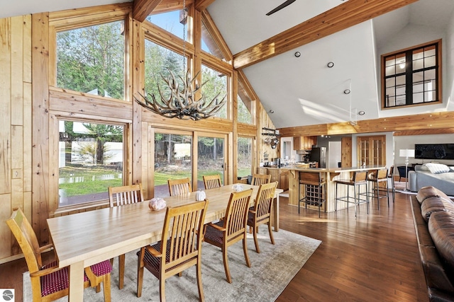 dining area featuring beamed ceiling, dark hardwood / wood-style floors, and high vaulted ceiling