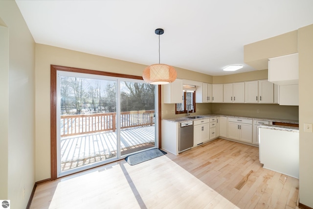 kitchen with pendant lighting, sink, dishwasher, light hardwood / wood-style floors, and white cabinets