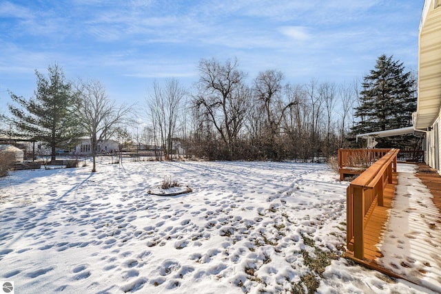 yard layered in snow featuring a wooden deck