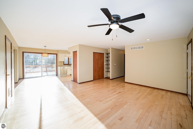 living room with ceiling fan and light wood-type flooring