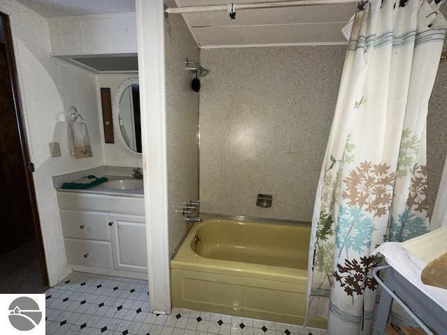 bathroom with shower / tub combo with curtain, vanity, and ornamental molding