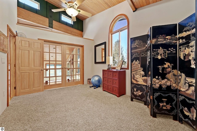 miscellaneous room with wood ceiling, carpet floors, ceiling fan, and a high ceiling