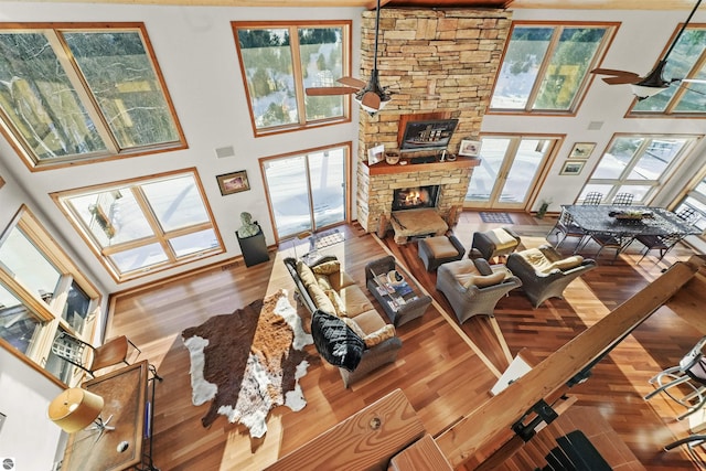 living room with hardwood / wood-style flooring, ceiling fan, and a fireplace