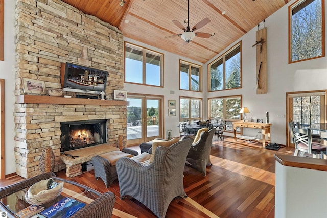 living room with french doors, wood ceiling, hardwood / wood-style flooring, ceiling fan, and a fireplace