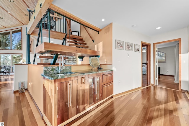 bar with hardwood / wood-style floors and sink