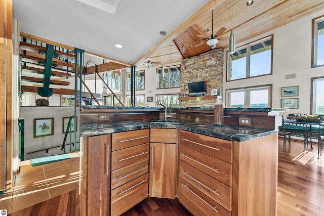 kitchen featuring a center island, dark wood-type flooring, sink, and dark stone counters