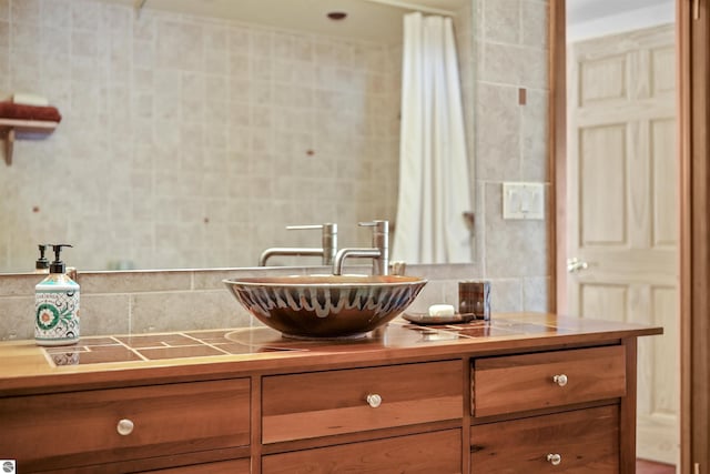 bathroom featuring tile walls, vanity, and decorative backsplash