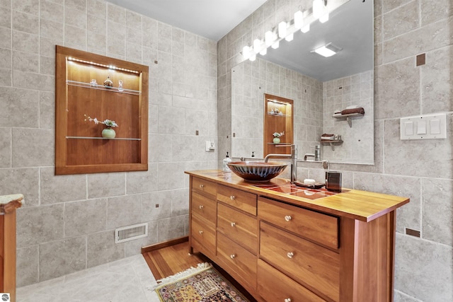 bathroom with tile walls, vanity, and tile patterned floors