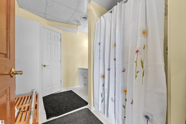 bathroom with a paneled ceiling and curtained shower