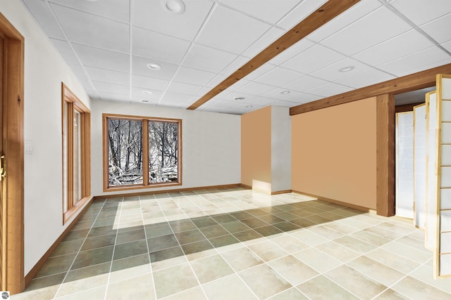 basement with a paneled ceiling and tile patterned floors