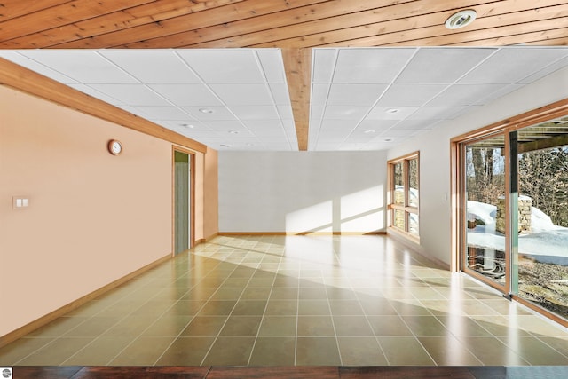 tiled empty room featuring a paneled ceiling