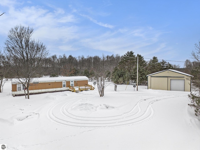 yard covered in snow with a garage and an outdoor structure