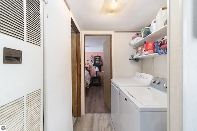 washroom with washing machine and dryer and light wood-type flooring