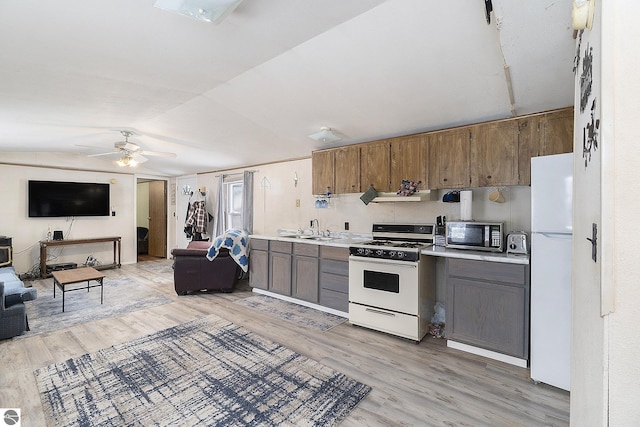 kitchen featuring lofted ceiling, sink, light wood-type flooring, ceiling fan, and white appliances