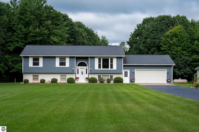 raised ranch featuring a garage and a front yard