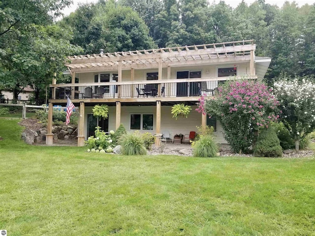 rear view of house featuring a yard, a pergola, and a deck