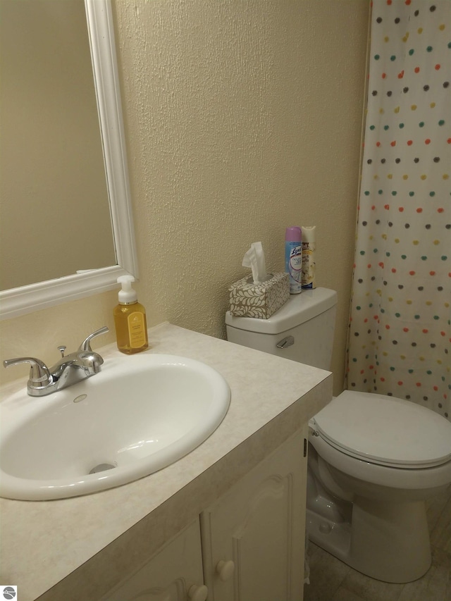 bathroom with vanity, toilet, and curtained shower