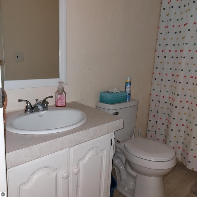 bathroom featuring vanity, walk in shower, and toilet