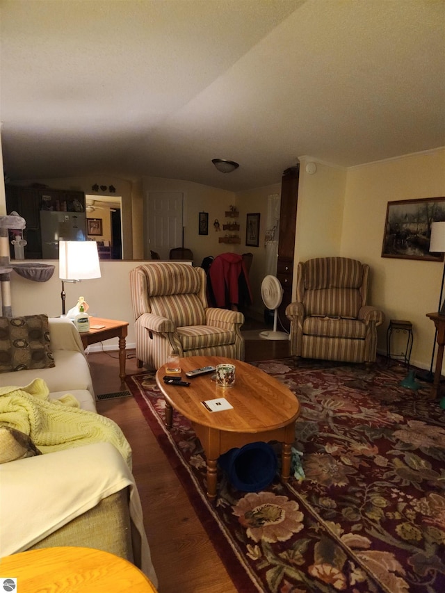 living room featuring dark hardwood / wood-style flooring and vaulted ceiling