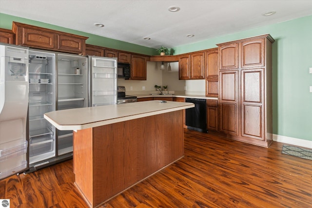 kitchen featuring sink, dark wood-type flooring, black appliances, and a kitchen island