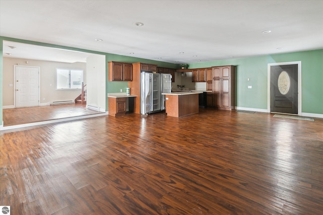 unfurnished living room featuring dark wood-type flooring and a baseboard radiator