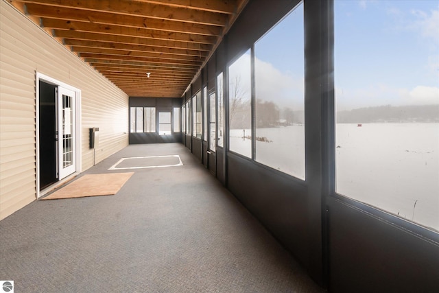 unfurnished sunroom featuring a water view