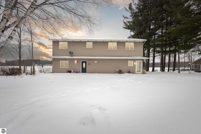 view of snow covered rear of property