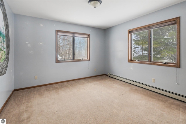 spare room featuring carpet flooring, a wealth of natural light, and a baseboard heating unit