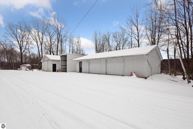 snow covered structure with a garage