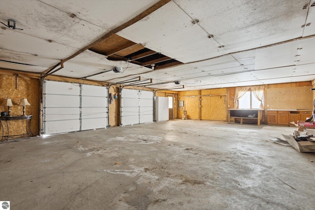 garage with a garage door opener and white fridge