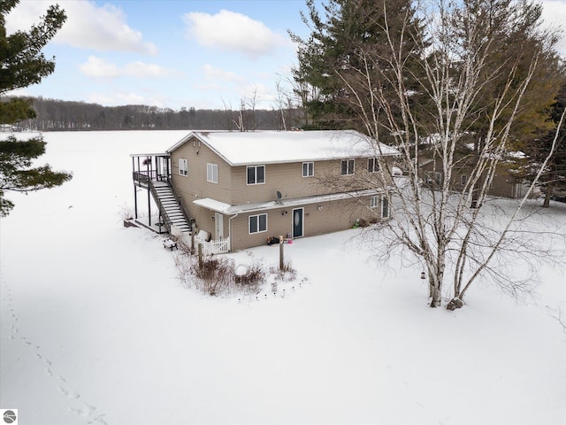 view of snow covered rear of property