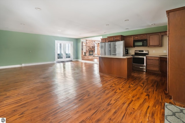 kitchen with stainless steel appliances, dark hardwood / wood-style flooring, a kitchen island, and a baseboard heating unit