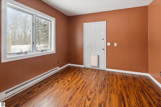 empty room featuring hardwood / wood-style floors and a baseboard radiator