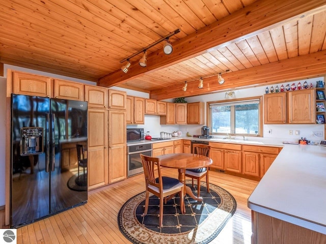 kitchen with sink, wood ceiling, light wood-type flooring, beam ceiling, and black appliances