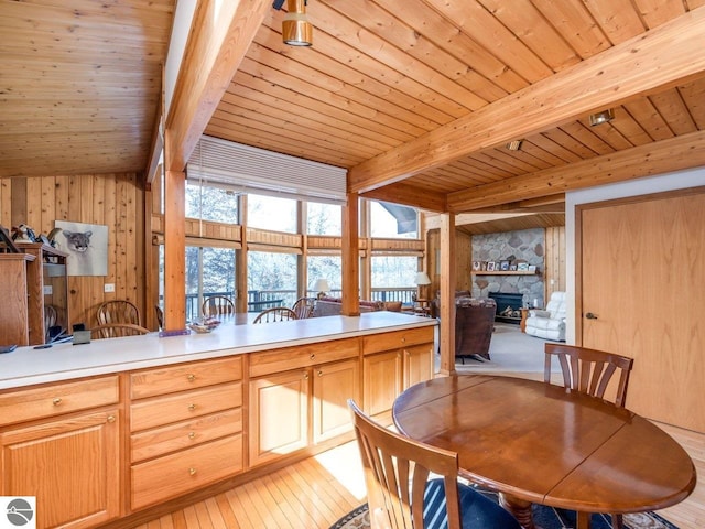 kitchen with a fireplace, a wealth of natural light, wooden ceiling, and beamed ceiling