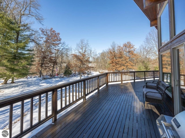 snow covered deck with a grill