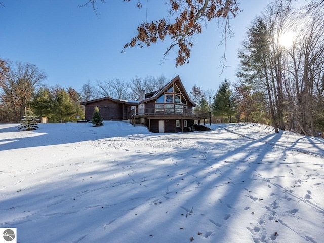 snow covered house featuring a wooden deck