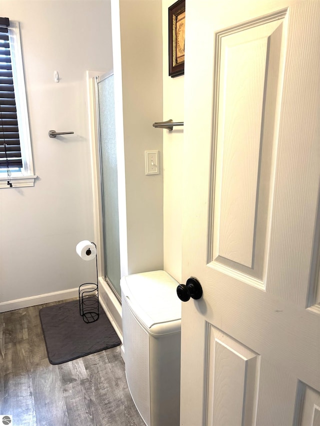 bathroom featuring wood-type flooring and a shower with door