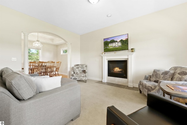 living room featuring light colored carpet and decorative columns