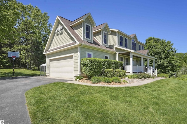 view of front of property featuring a porch, a garage, and a front lawn