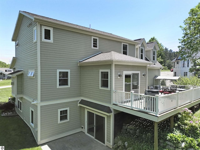 rear view of property featuring a deck