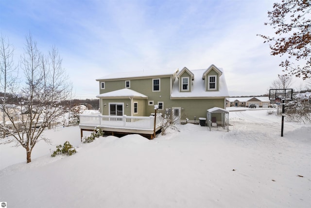 snow covered house with a wooden deck