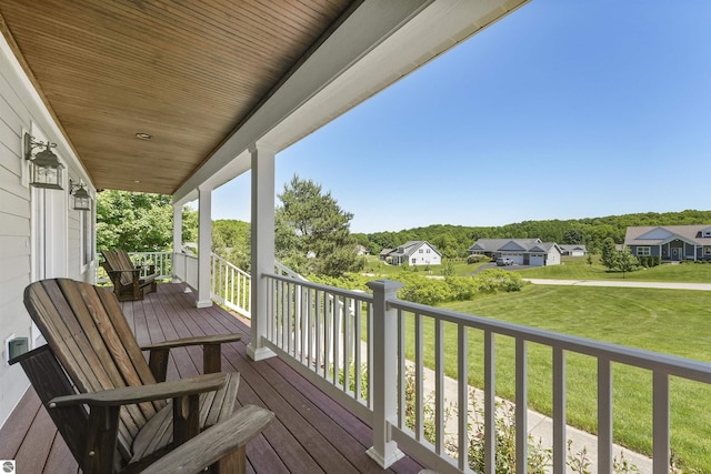 wooden deck featuring a lawn and a porch