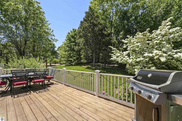 wooden terrace featuring a grill and a lawn