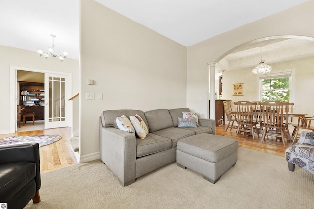 living room featuring hardwood / wood-style floors, a chandelier, and ornate columns