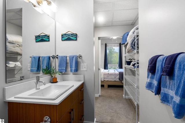 bathroom with a paneled ceiling and vanity