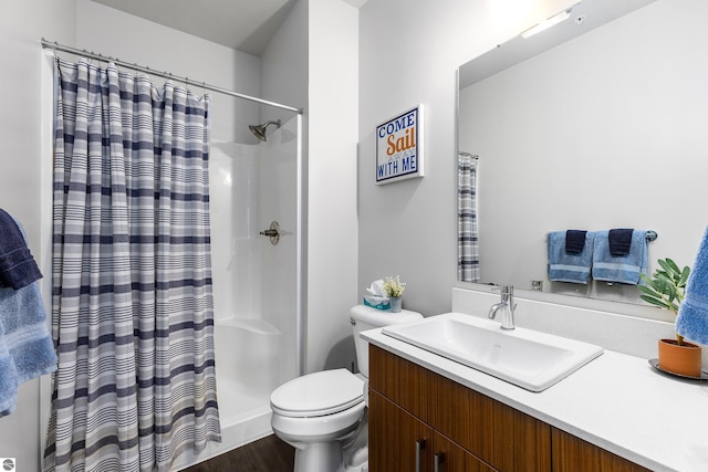 bathroom featuring hardwood / wood-style flooring, vanity, toilet, and curtained shower