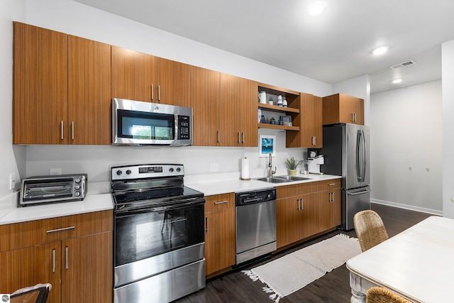 kitchen featuring stainless steel appliances, sink, and dark hardwood / wood-style flooring